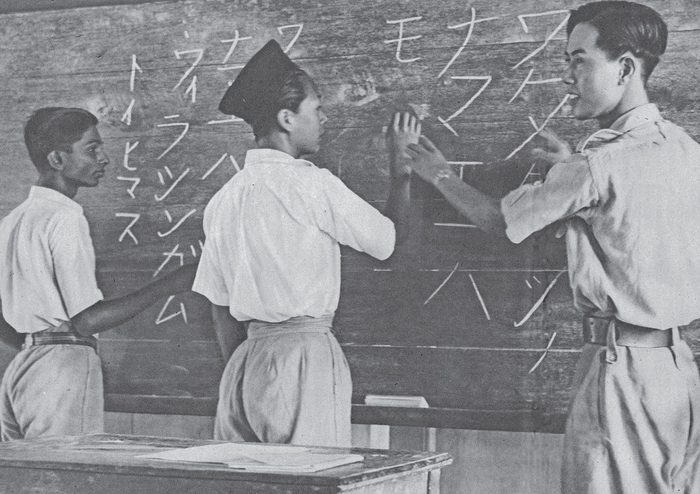 Japanese soldier teaching Singaporean students Japanese writing at a blackboard, 1943